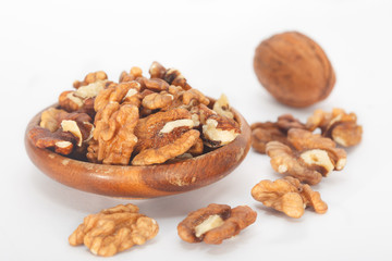 Walnut kernels and whole walnuts on white backround