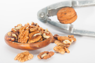 Cracking walnuts with nutcracker over white background