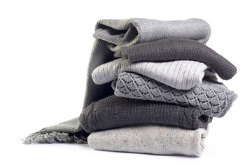 Stack of various sweaters isolated on white background