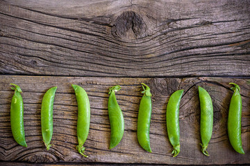 fresh green peas over a natural wood table, placed in  nice way
