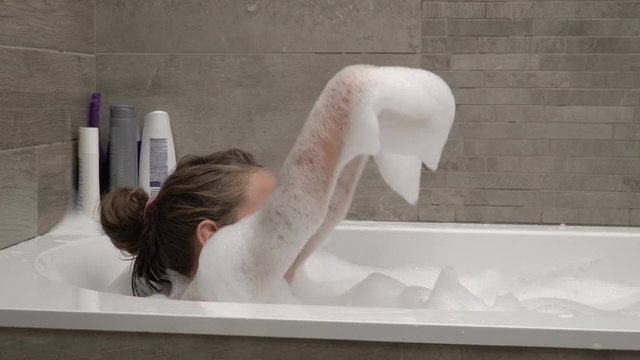 Little girl taking a bath with foam