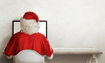 Santa Claus responds to letter of wishes on a computer. Front view of Santa Claus office. Free...
