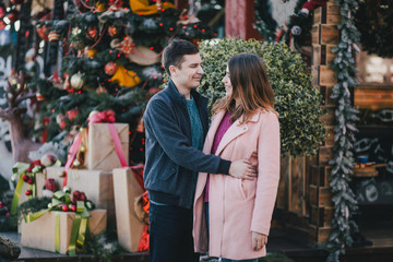 Happy couple in warm clothes posing on a Christmas market. Holiday mood