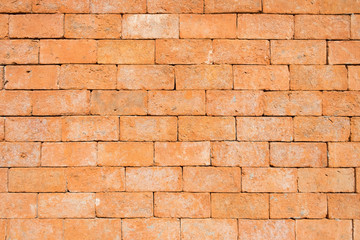 the old and dirty orange brick wall in warm or hot color tone/style with black stain for background texture