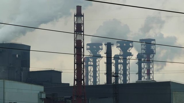 Emissions from the chimneys of the plant, flames and toxic fumes pollutes the environment, timelapse 4k
