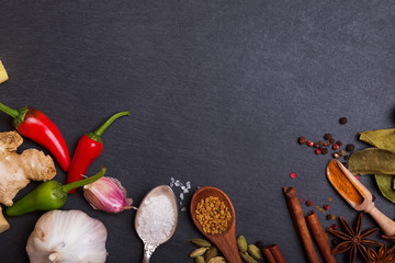 Fresh and dry spices on black stone background