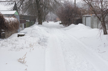 Naklejka premium Snow-covered small street of the Dnepropetrovsk city's suburb after snowfall and icing over