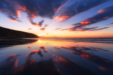 Fototapeta na wymiar Barinatxe beach with cloud reflections at sunset