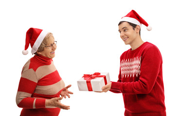 Young man giving a christmas present to elderly lady