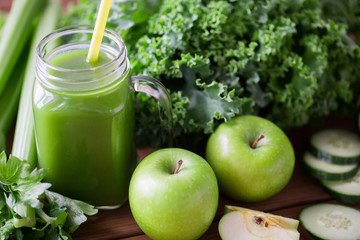 close up of jug with green juice and vegetables