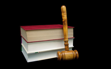 books and a wooden judge's gavel on a black background