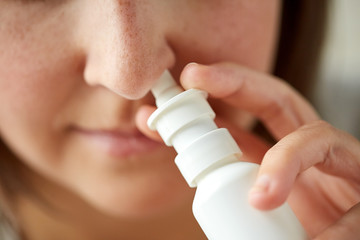 close up of sick woman using nasal spray - obrazy, fototapety, plakaty