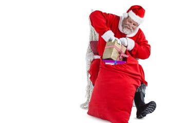 Santa claus putting presents in christmas bag
