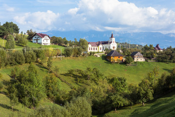 Landscape of Magura village houses and hills with the Carpathian mountains in background