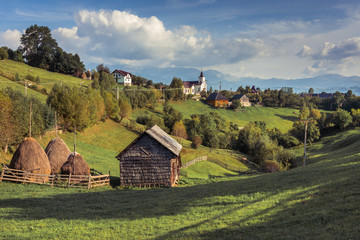 Landscape of Magura village houses and hills with the Carpathian mountains in background