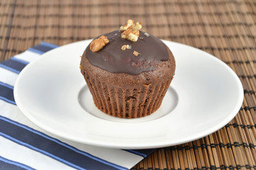 one chocolate brown muffins on white plate with color napkin best dessert