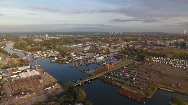 Aerial footage by drone of North Amsterdam industrial area, harbor and houses at the horizon.