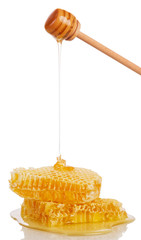 Honeycombs and honey flowing down from ladle isolated on white.