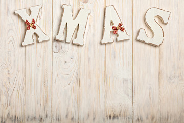 Wooden white XMAS letters on a white wooden background.