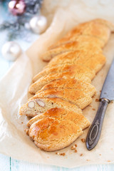 Christmas baking - freshly baked and slices loaf of Italian cantuccini biscuits with festive decorations at the background. Shallow depth of field with selective focus