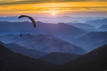 Poster Paragliden en de zonsopgang © Bashkatov