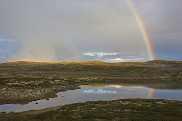 Rainbow above the lake on the mountain plateau, Norway
