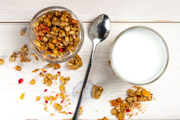 Granola, milk and honey in a glass.