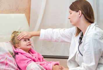 Obraz premium Doctor touches the forehead a little sick girl in bed