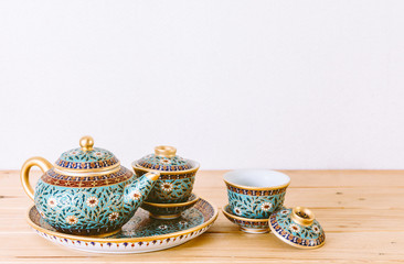 Teapot with cup of tea on wooden table