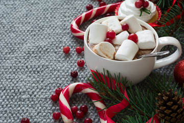 Christmas decoration. Hot chocolate with marshmallow on grey knitted background