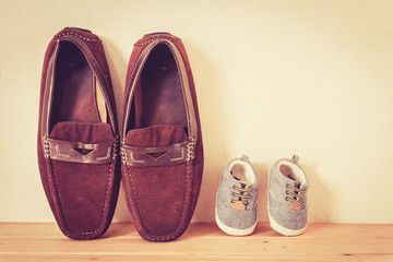 Father and baby shoe  on wooden table