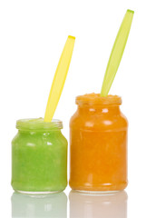 Opened jars baby vegetable puree with plastic spoon isolated.