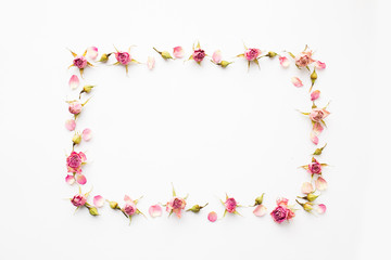 Fototapeta na wymiar Frame made of pink dry roses and petals. Top view, greeting card.