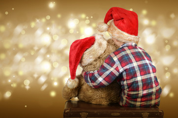 Kind mit Weihnachtsmütze und Teddybär