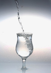  water is poured from a bottle into a glass