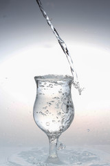  water is poured from a bottle into a glass