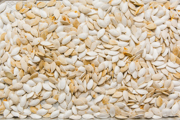 Raw pumpkins seeds and pumpkin.