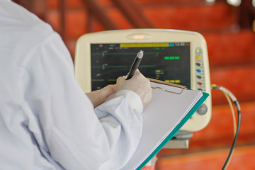 Asian female doctor  writing medical report