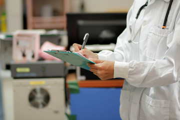 Asian female doctor  writing medical report