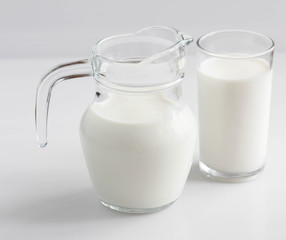 Natural whole milk in a jug and a glass
