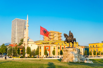 Skanderbeg square with flag, Skanderbeg monument and The Et'hem Bey Mosque in the center of Tirana city, Albania. - obrazy, fototapety, plakaty