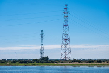 High-voltage  power line with two towers on the river bank