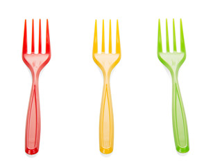 Bright plastic forks close up on background light wood.