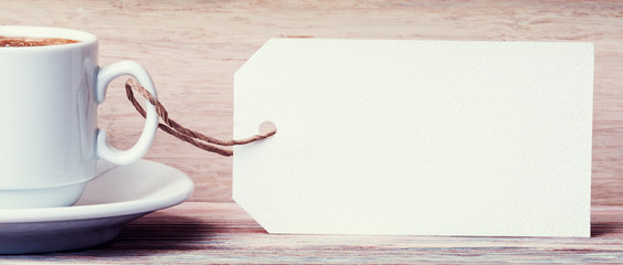 Coffee cup with empty label mock-up over old wooden background