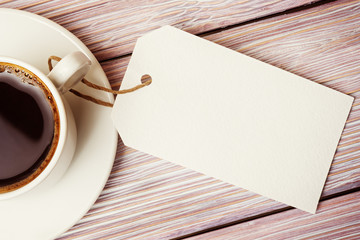 Coffee cup with empty label mock-up over wooden background