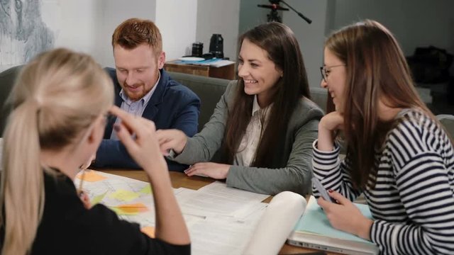 Woman offers good idea everyone is happy, high-fiving each other Creative business team meeting in startup office