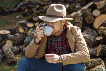 Man cowboy hat drinking morning coffee in countryside