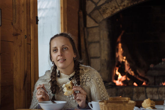 Young Woman Eating Soup In A Wooden Cafe On The Background Of Th