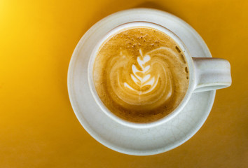 Cup of latte coffee on yellow Leather table