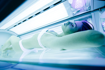 Beautiful woman tanning in solarium